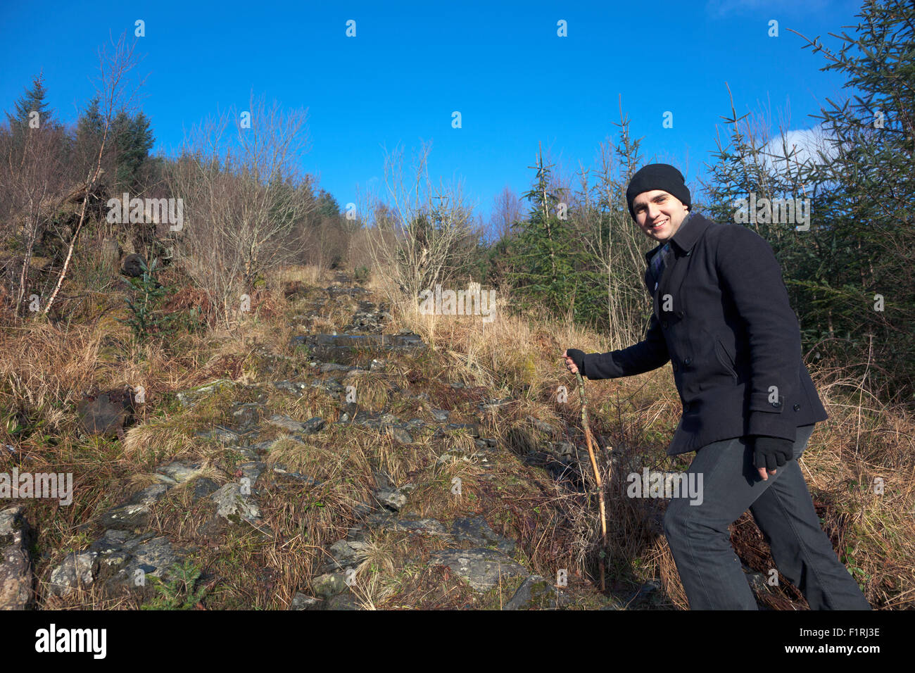 Hiker climbing a mountain in Scotland Stock Photo
