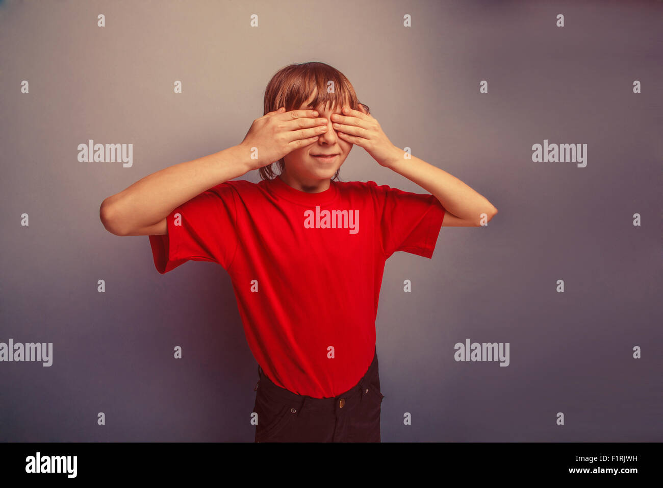 boy, teenager, twelve years in  red T-shirt, eyes  closed hands Stock Photo