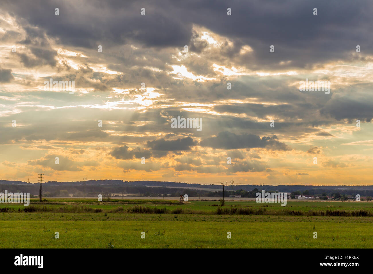 Dramatic sunset over green field Stock Photo
