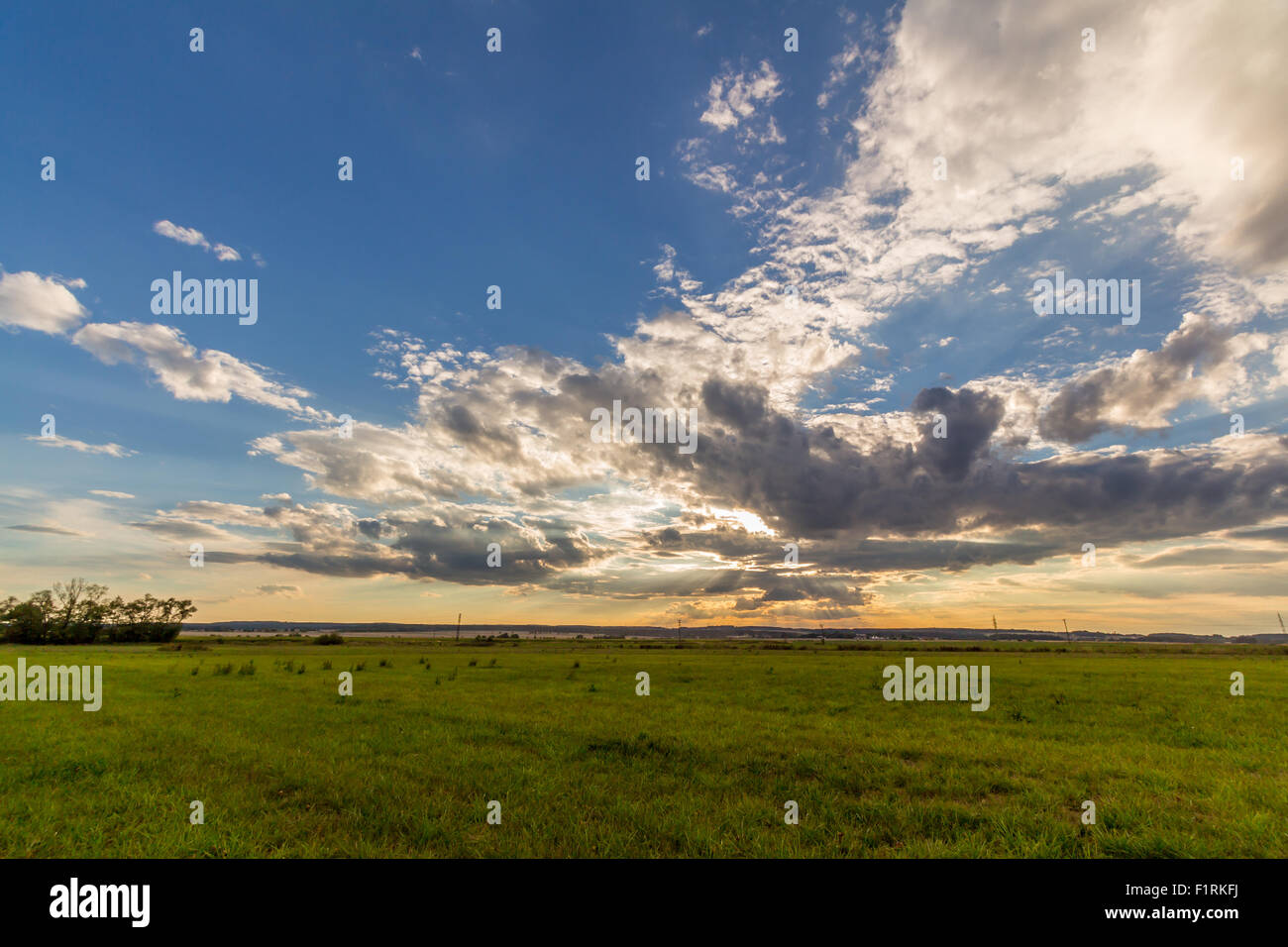 Dramatic sunset over green field Stock Photo