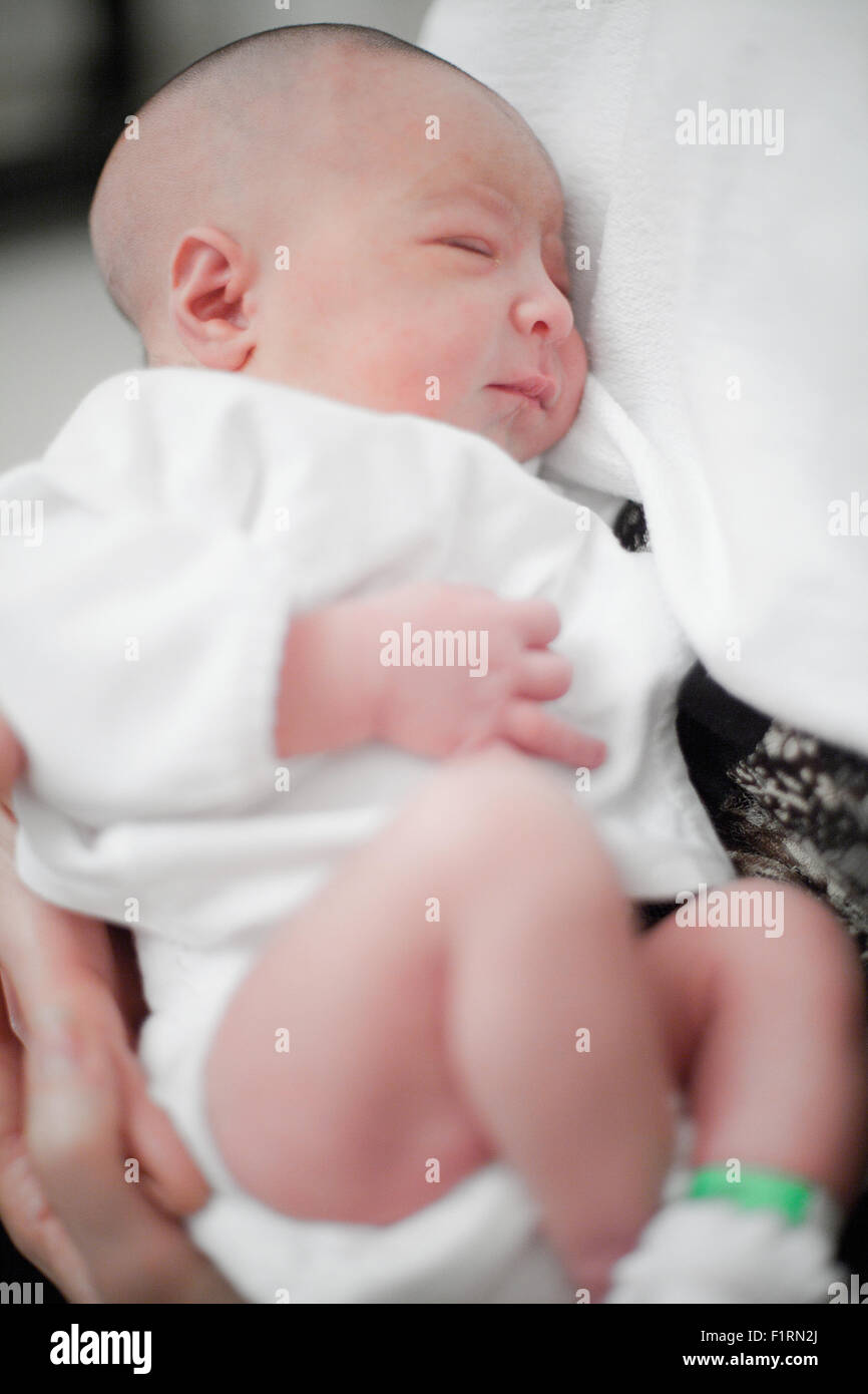 Cute newborn baby girl sleeping in mother's arms Stock Photo