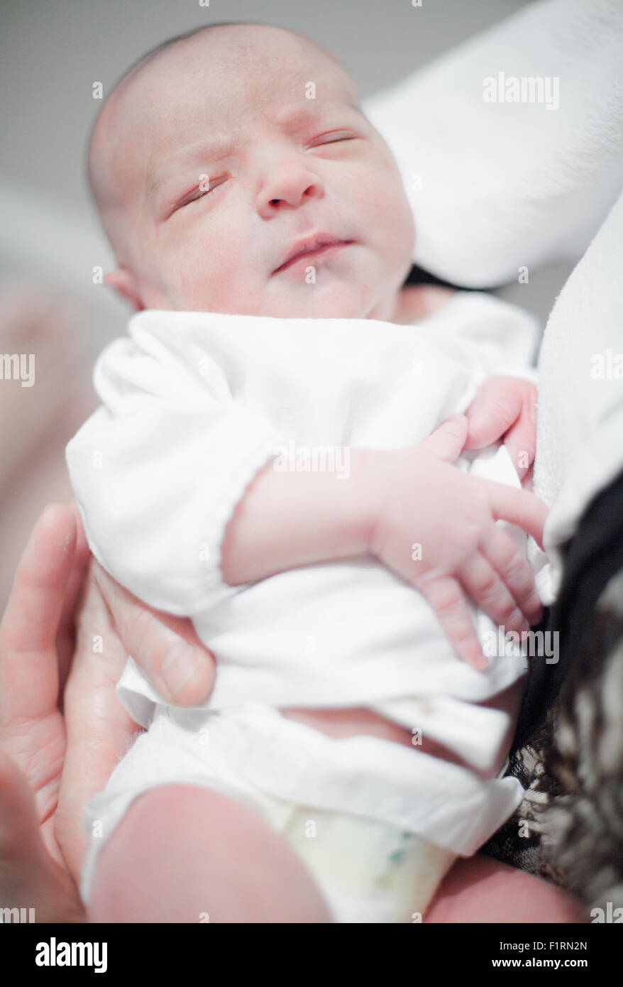 Cute newborn baby girl sleeping in mother's arms Stock Photo