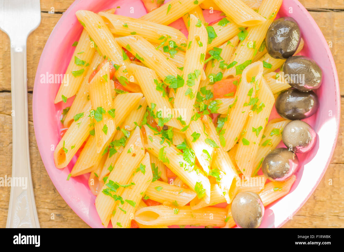Penne pasta in tomato sauce in a plate. Rustic style Stock Photo - Alamy