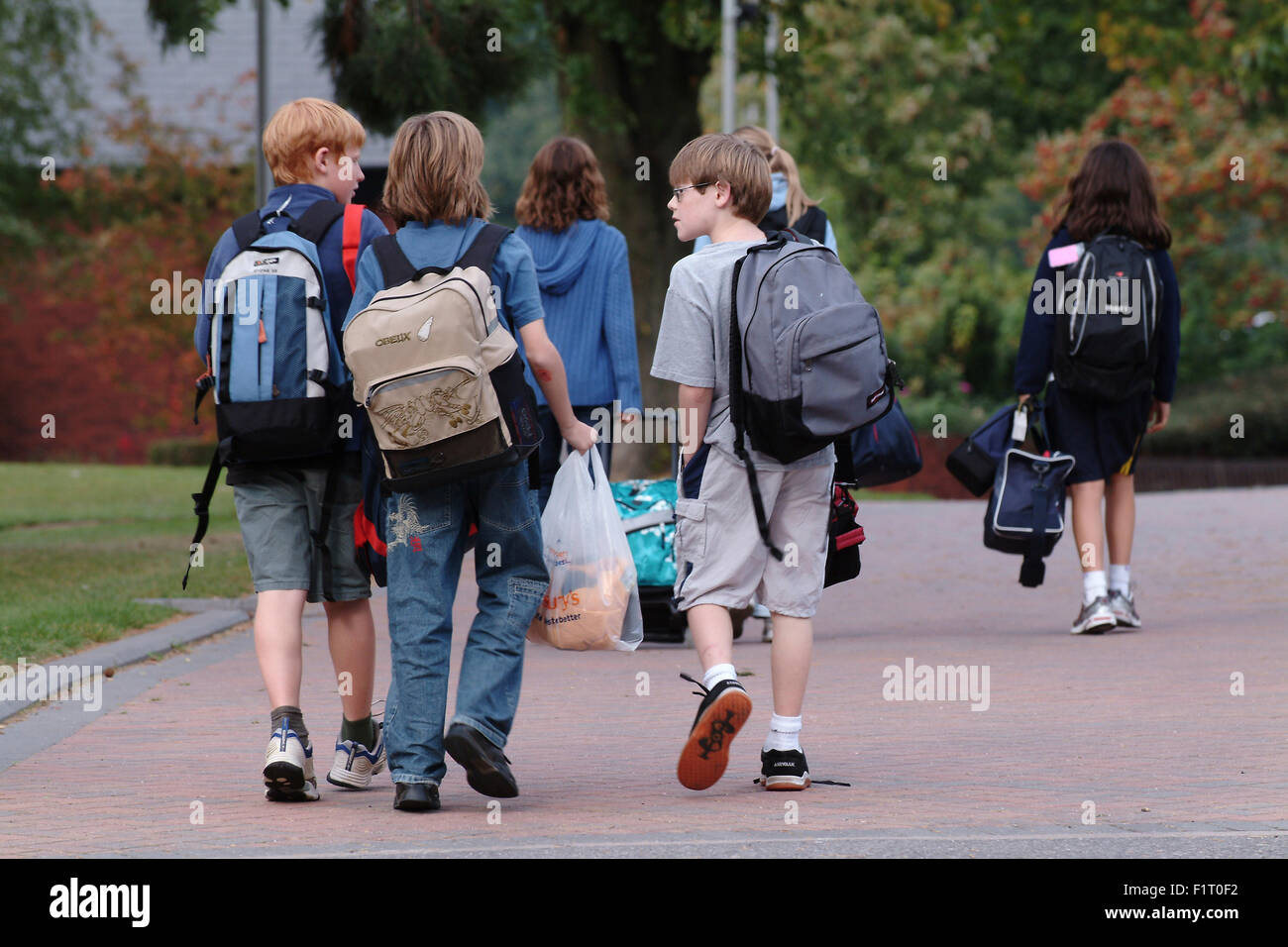 Children leaving school with backpacks, walking away from camera Stock  Photo - Alamy