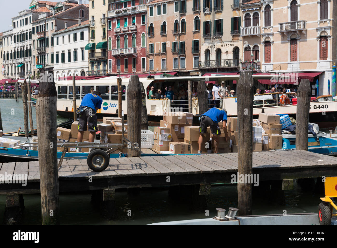 Transport workmen unloading a canal boat in Venice Italy Stock Photo ...