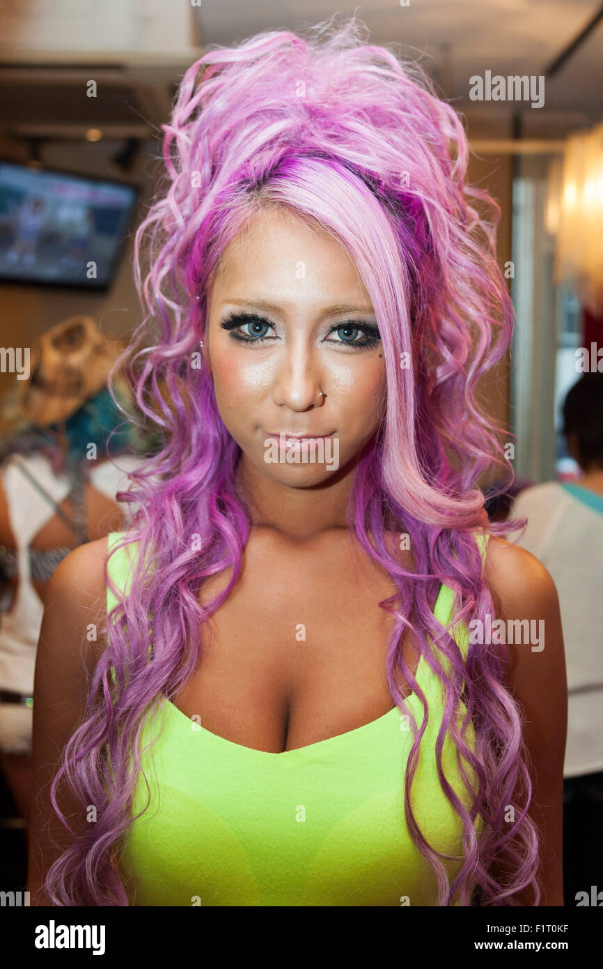 Ayuyun, a member of staff, poses for a picture at the Ganguro Cafe & Bar in the Shibuya shopping area on September 4, 2015. Ganguro is an alternative Japanese fashion trend which started in the mid-1990s where young women, rebelling against the traditional idea of Japanese beauty, wore colorful make-up and clothes and had dark-skin. 10 Ganguro fashion girls work in the new bar, which offers original Ganguro Balls (fried takoyaki style sausage balls in black squid ink batter) on its menu. Ganguro Café & Bar also offers special services such as Ganguro make-up and the chance to take purikura Stock Photo