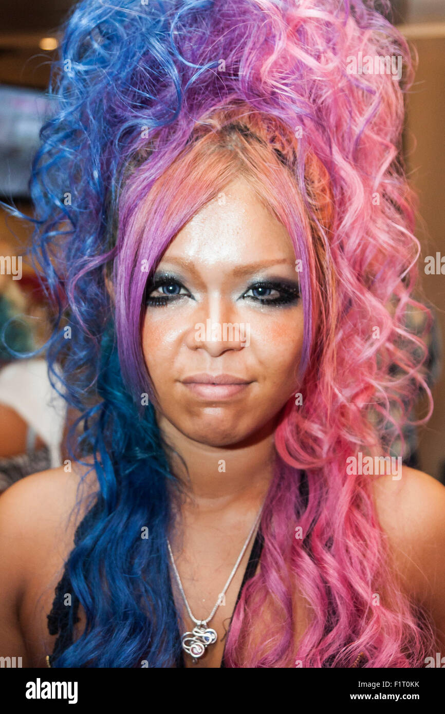 A member of staff poses for a picture at the Ganguro Cafe & Bar in the Shibuya shopping area on September 4, 2015. Ganguro is an alternative Japanese fashion trend which started in the mid-1990s where young women, rebelling against the traditional idea of Japanese beauty, wore colorful make-up and clothes and had dark-skin. 10 Ganguro fashion girls work in the new bar, which offers original Ganguro Balls (fried takoyaki style sausage balls in black squid ink batter) on its menu. Ganguro Café & Bar also offers special services such as Ganguro make-up and the chance to take purikura (photo bo Stock Photo