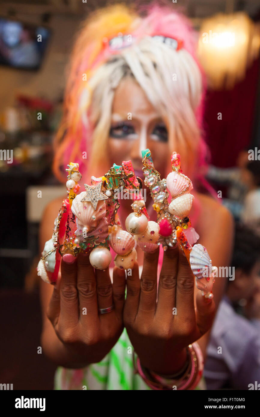 Ayuyun, a member of staff, shows off her nail art at the Ganguro Cafe & Bar in the Shibuya shopping area on September 4, 2015. Ganguro is an alternative Japanese fashion trend which started in the mid-1990s where young women, rebelling against the traditional idea of Japanese beauty, wore colorful make-up and clothes and had dark-skin. 10 Ganguro fashion girls work in the new bar, which offers original Ganguro Balls (fried takoyaki style sausage balls in black squid ink batter) on its menu. Ganguro Café & Bar also offers special services such as Ganguro make-up and the chance to take puriku Stock Photo
