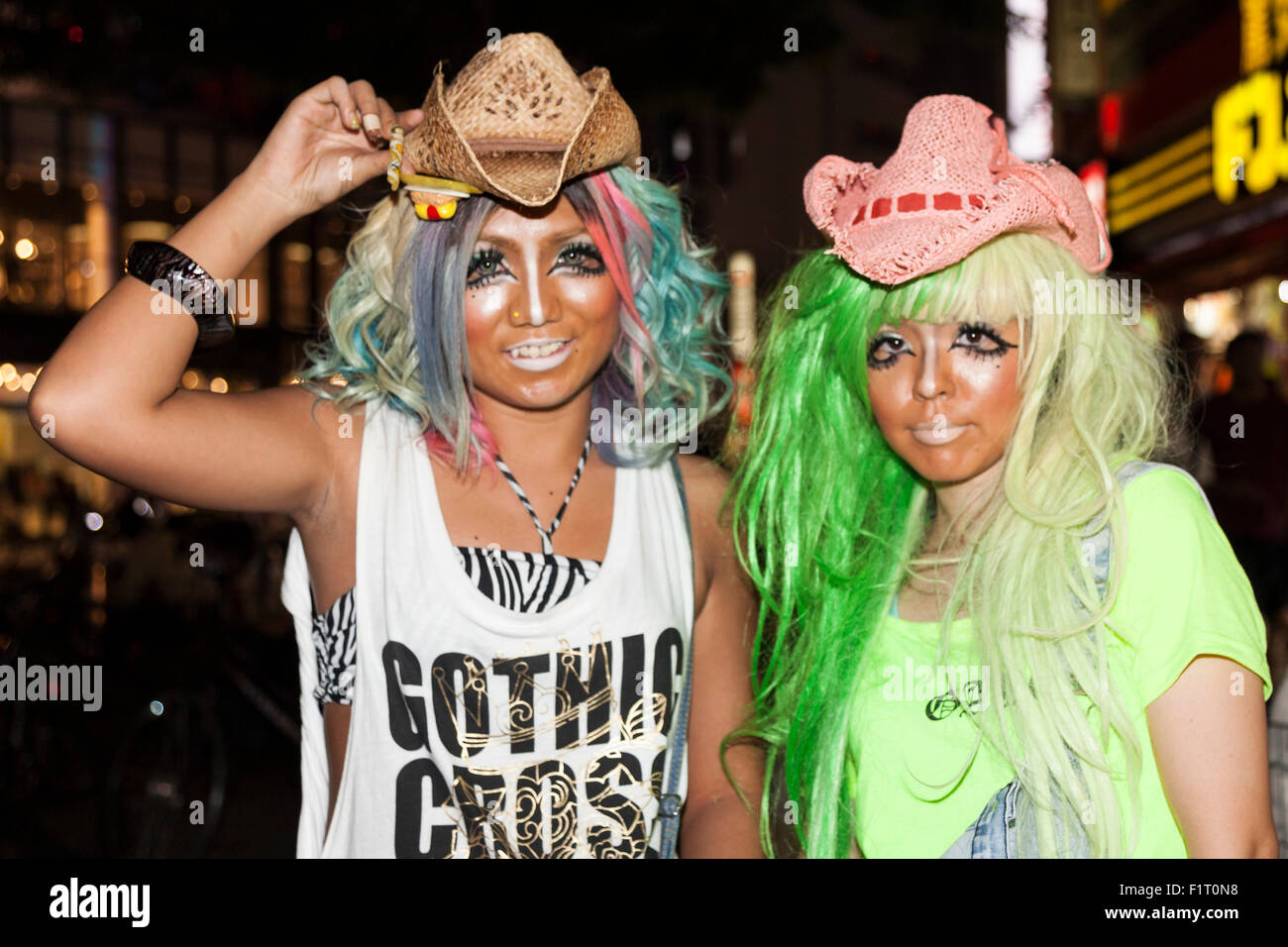 (L to R) Erimokkori of the Ganguro Cafe & Bar with a female customer who has been transformed into a ganguro girl pose of pictures in the Shibuya shopping area on September 4, 2015. Ganguro is an alternative Japanese fashion trend which started in the mid-1990s where young women, rebelling against the traditional idea of Japanese beauty, wore colorful make-up and clothes and had dark-skin. 10 Ganguro fashion girls work in the new bar, which offers original Ganguro Balls (fried takoyaki style sausage balls in black squid ink batter) on its menu. Ganguro Café & Bar also offers special service Stock Photo