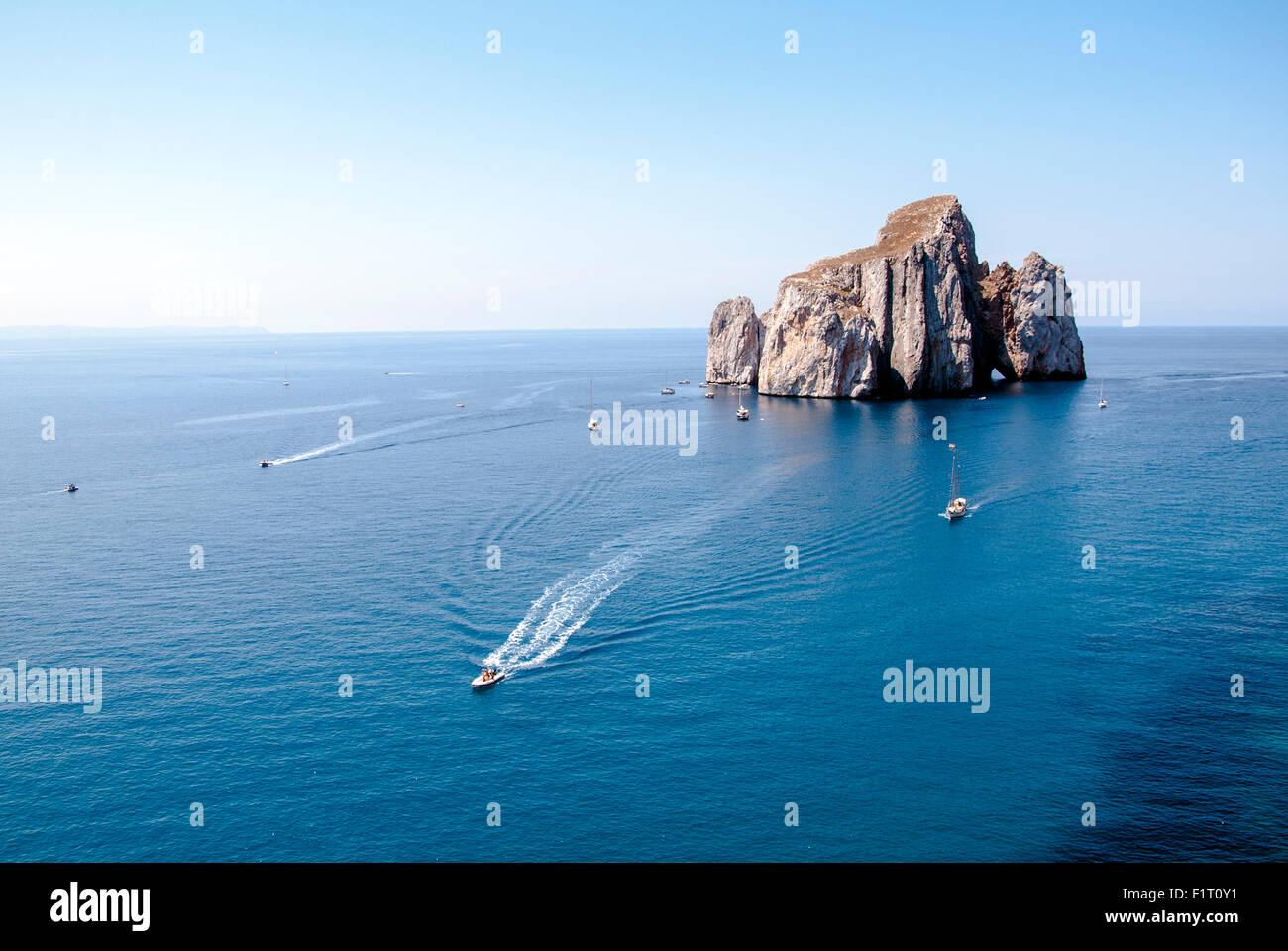 Pan di Zucchero (Nebida Sardinia). A rocky island in the center of the sea with ships sailing around. Top view Stock Photo