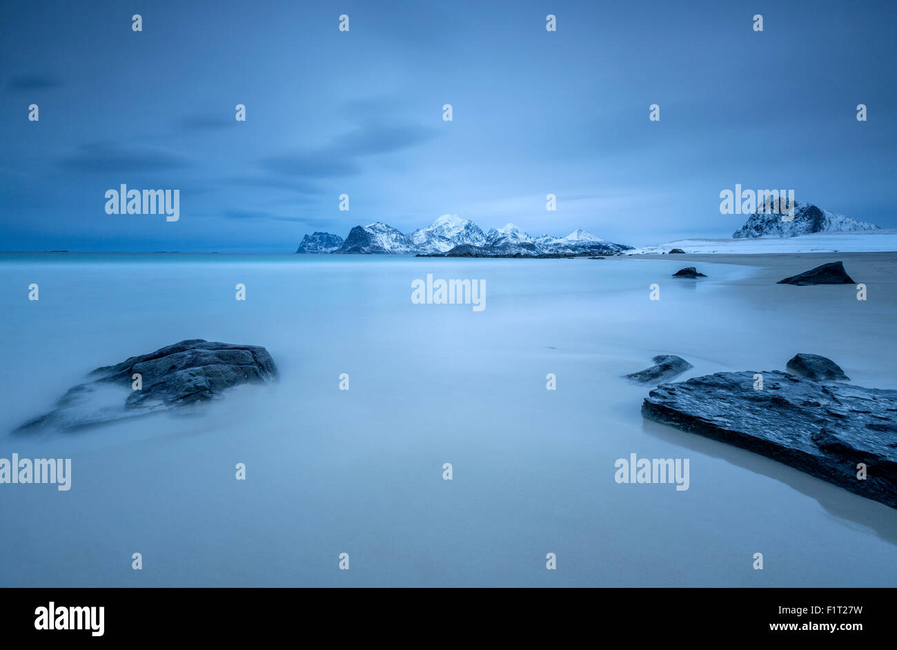 The cold blue sea bathes the beach still partially snowy. Myrland, Lofoten Islands, Northern Norway, Scandinavia, Arctic, Europe Stock Photo