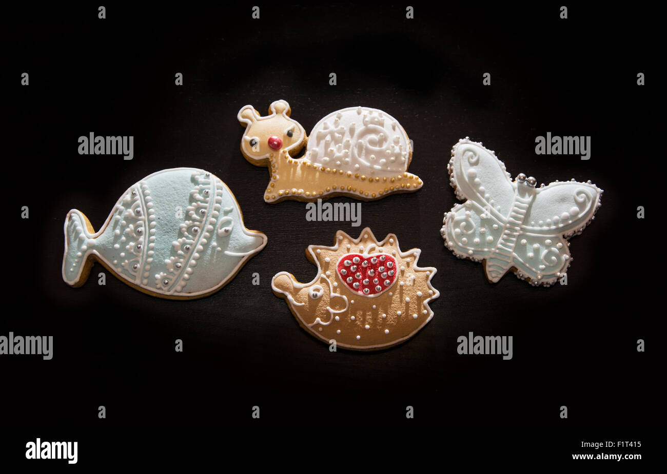 Gingerbread cookies on the dark background. Fish, snail, hedgehog and butterfly. Christmas theme. Stock Photo