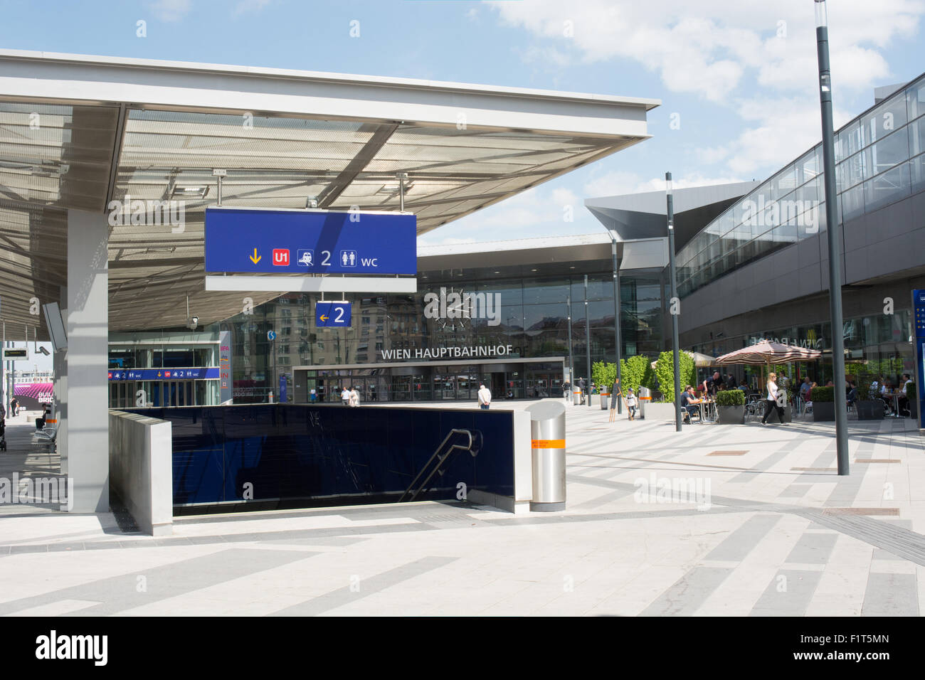 The glass and steel frontage of Wein Huptbahnhoff (Vienna Railway station) . Signs above an entrance help guide travelers Stock Photo