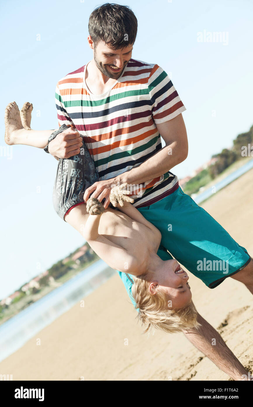 Father on beach fooling around with son Stock Photo