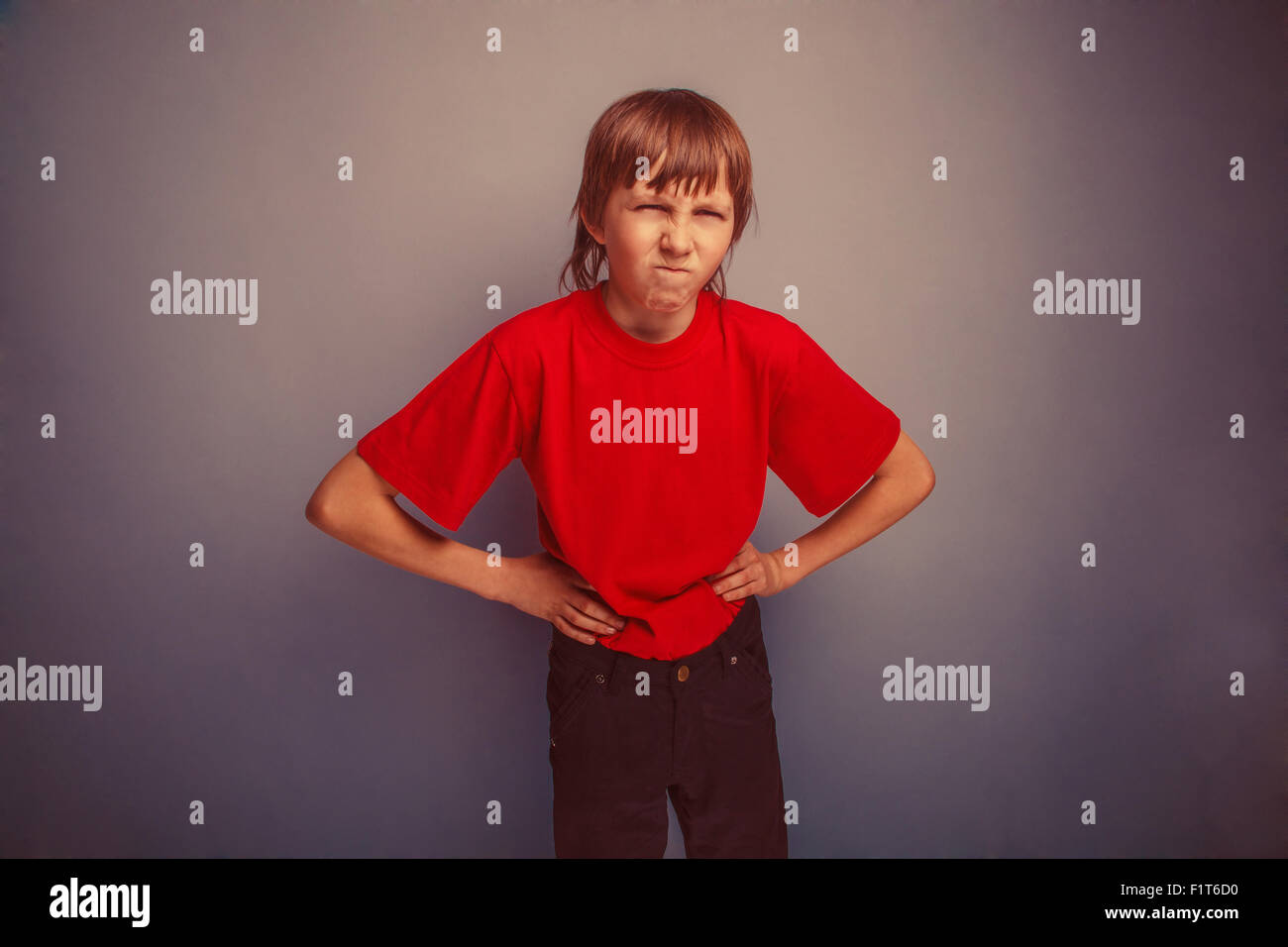 Boy, teenager, twelve years in the red shirt,  hands in the side Stock Photo