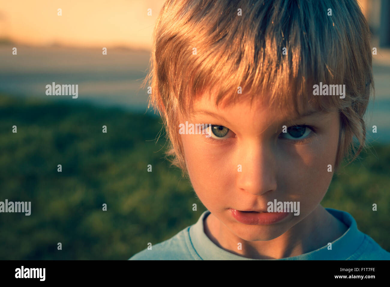 Young boy outdoors looking at camera Stock Photo - Alamy