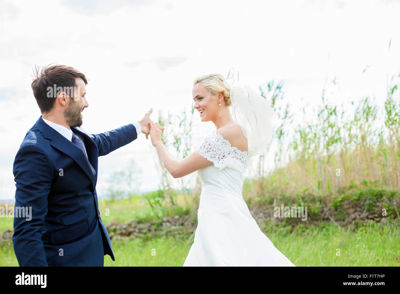 Bride and groom dancing in the meadow Stock Photo
