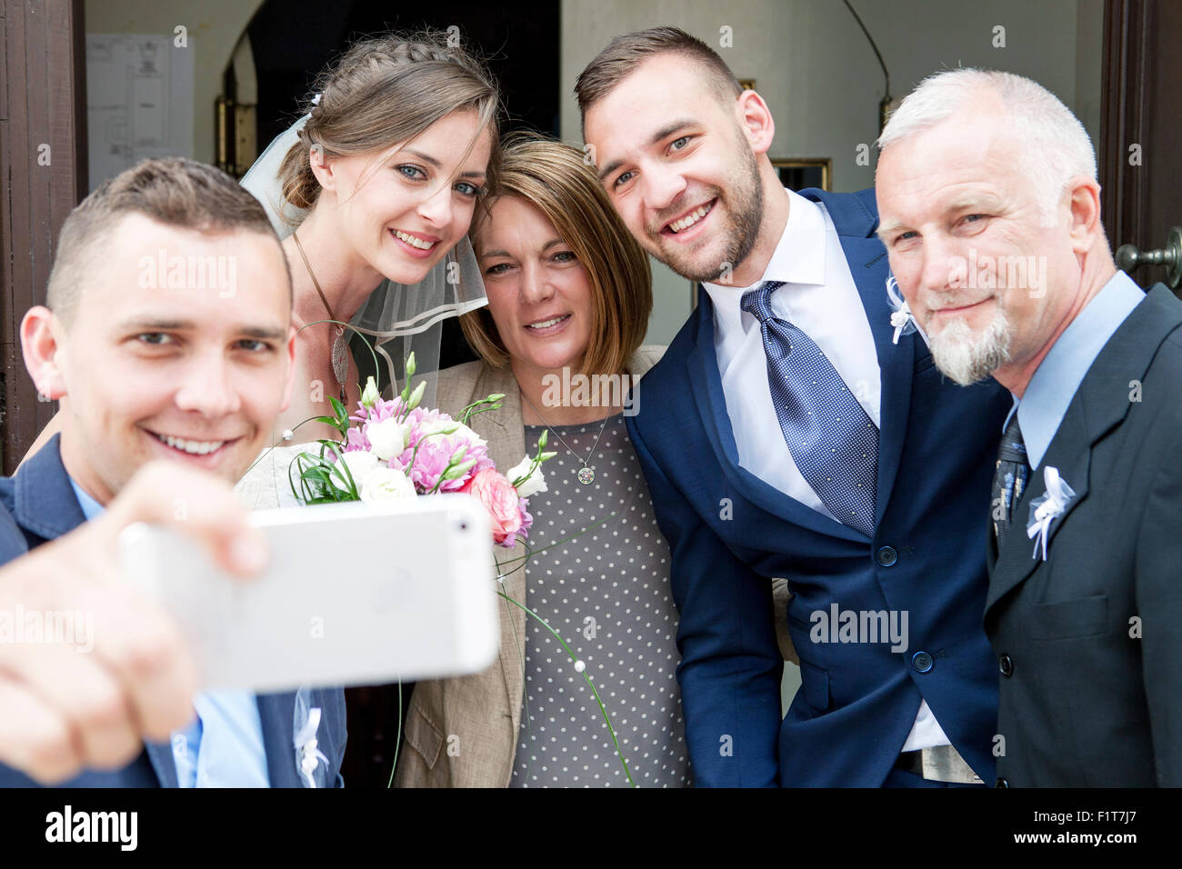 Groom, bride and family taking photo of themselves Stock Photo