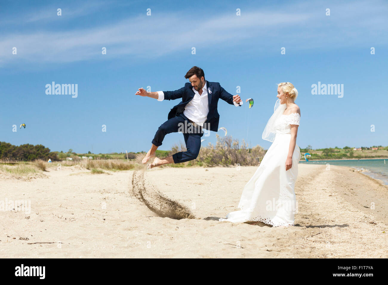 Bride and bridegroom on beach having fun Stock Photo