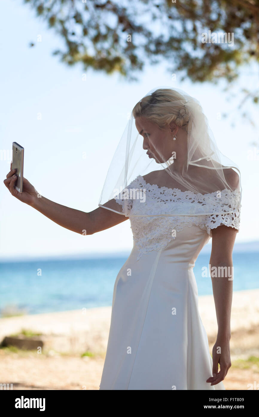 Bride with veil taking photo of herself Stock Photo