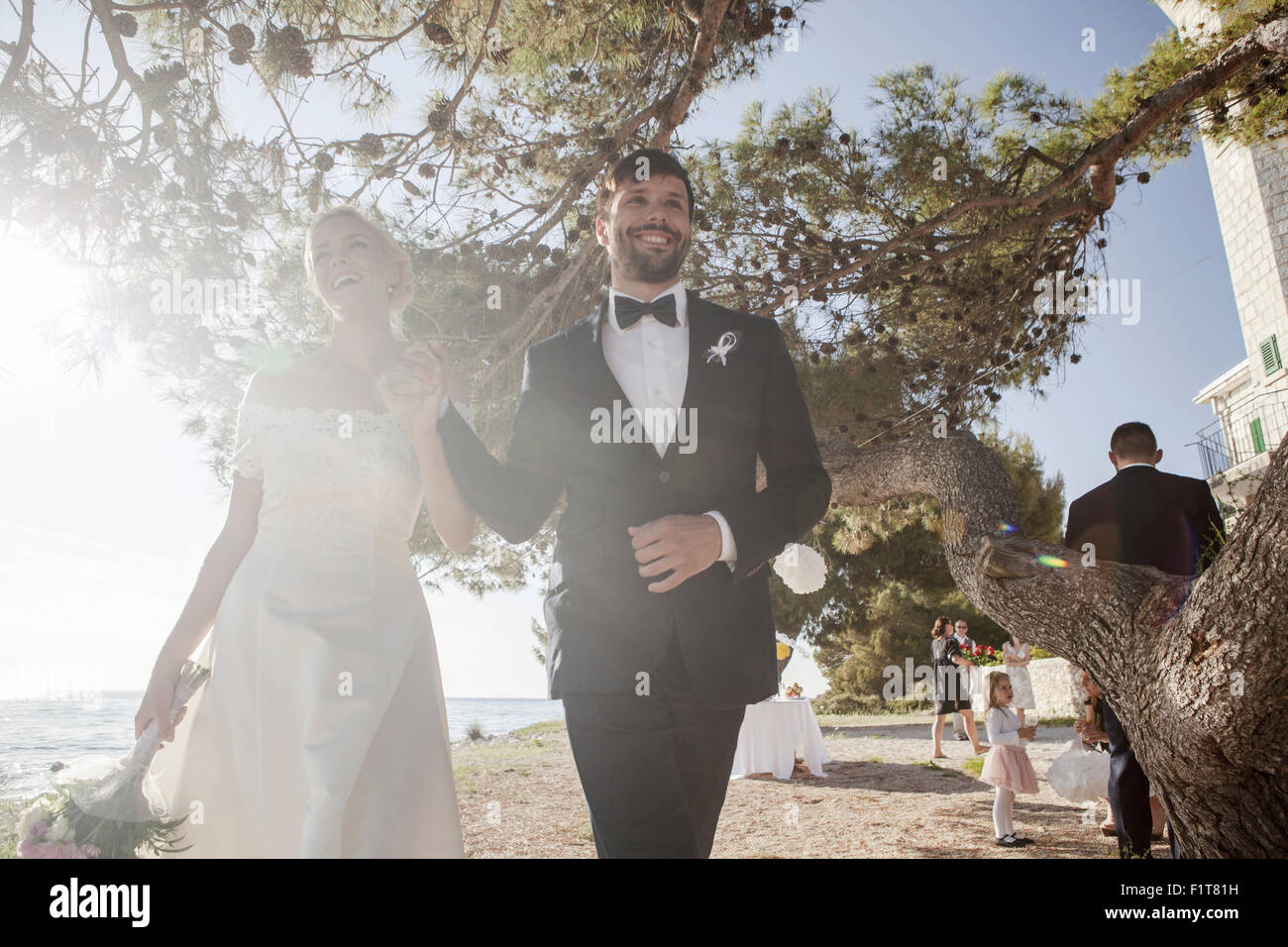 Bride and groom holding hands outdoors Stock Photo - Alamy