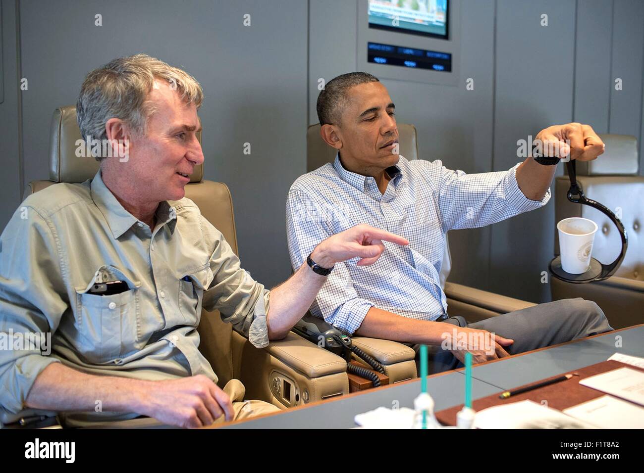 U.S. President Barack Obama talks with Bill Nye, the Science Guy, aboard Air Force One en route to Miami April 22, 2015. Stock Photo
