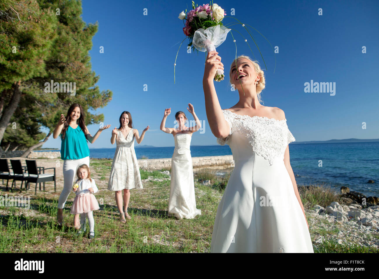Bride throwing bouquet at wedding reception Stock Photo