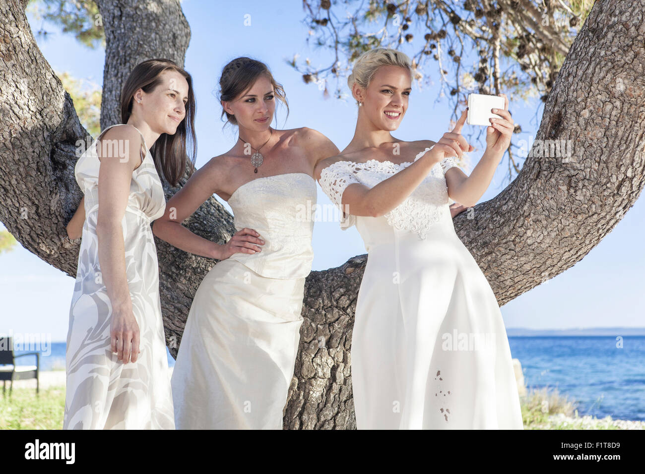 Bride and bridesmaids taking photo of themselves Stock Photo