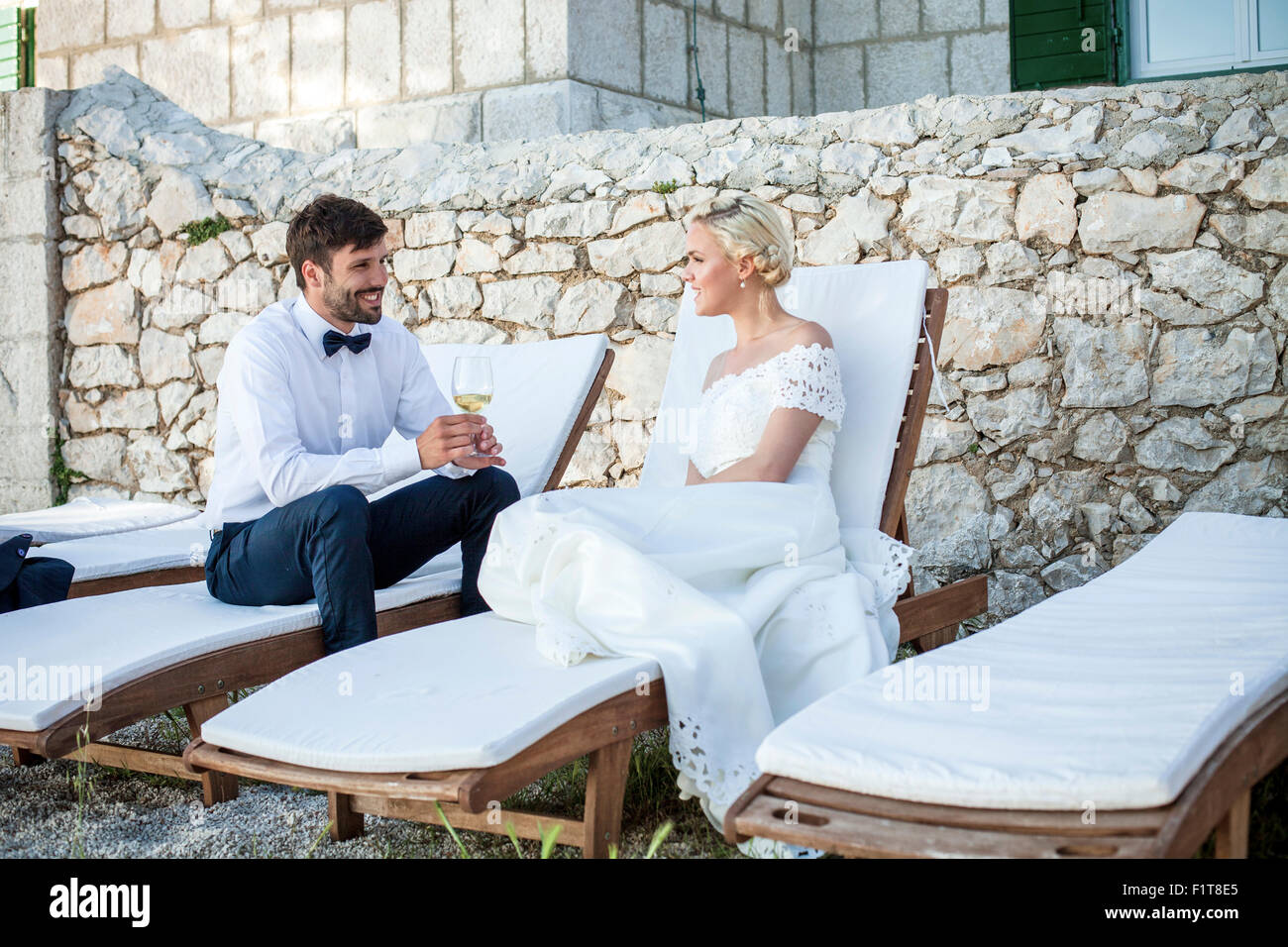 Bridegroom and bride drinking champagne outdoors Stock Photo