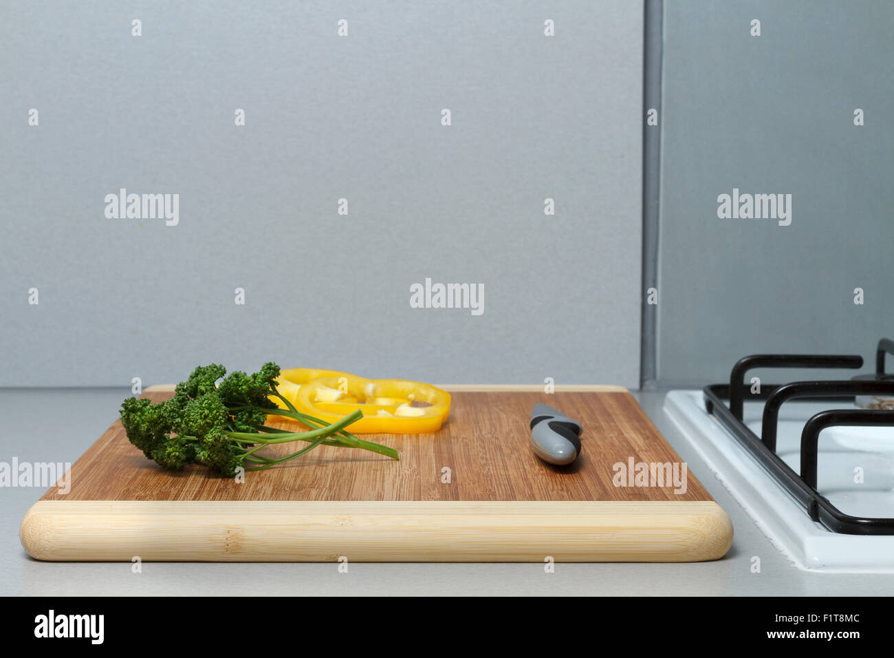 Cutting board with herbs sliced pepper and a knife. Stock Photo