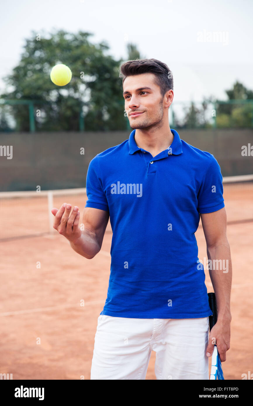 Portrait of a handsome male tennis player standing outdoors Stock Photo