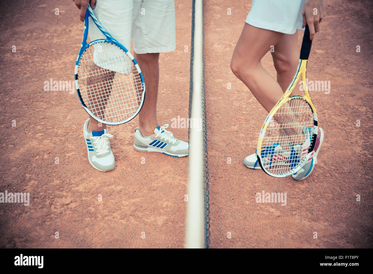 Closeup portrait of female and male legs at the tennis court Stock Photo