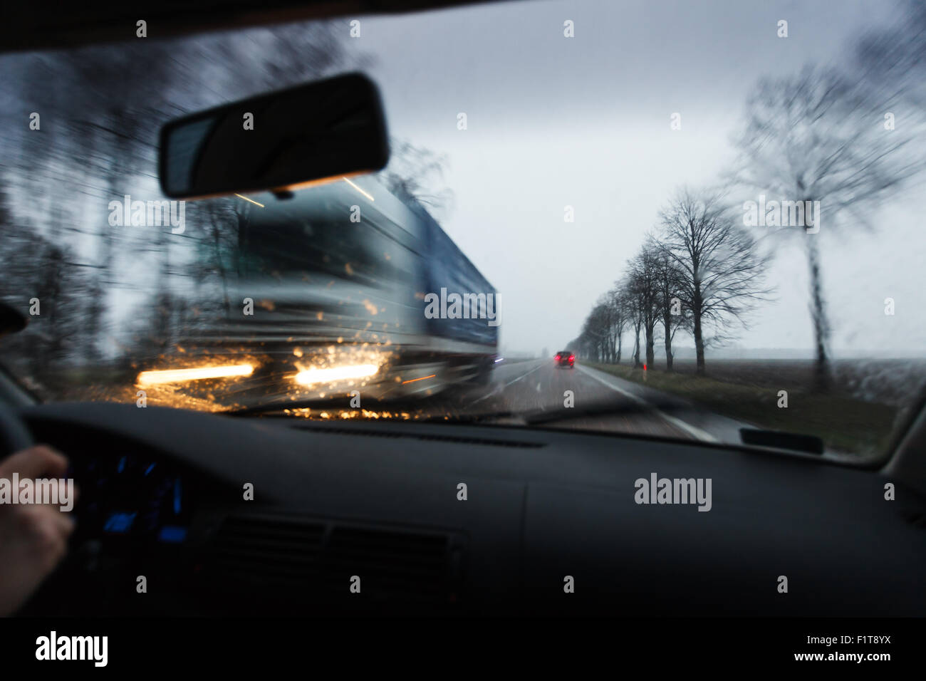 Bad weather conditions driving a car, passing truck Stock Photo