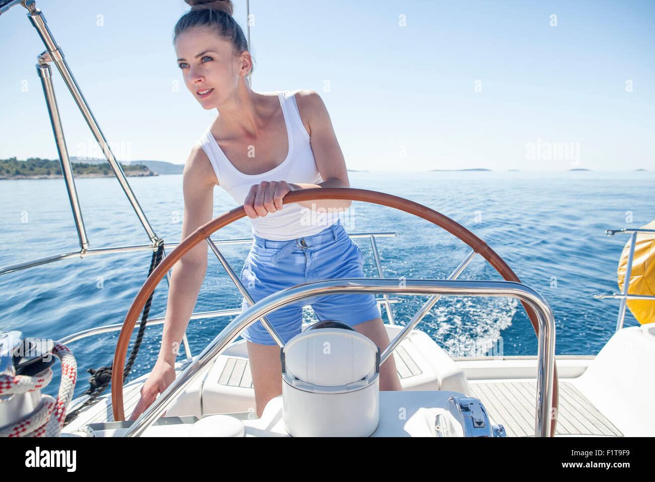 Young woman steering on sailboat, Adriatic Sea Stock Photo