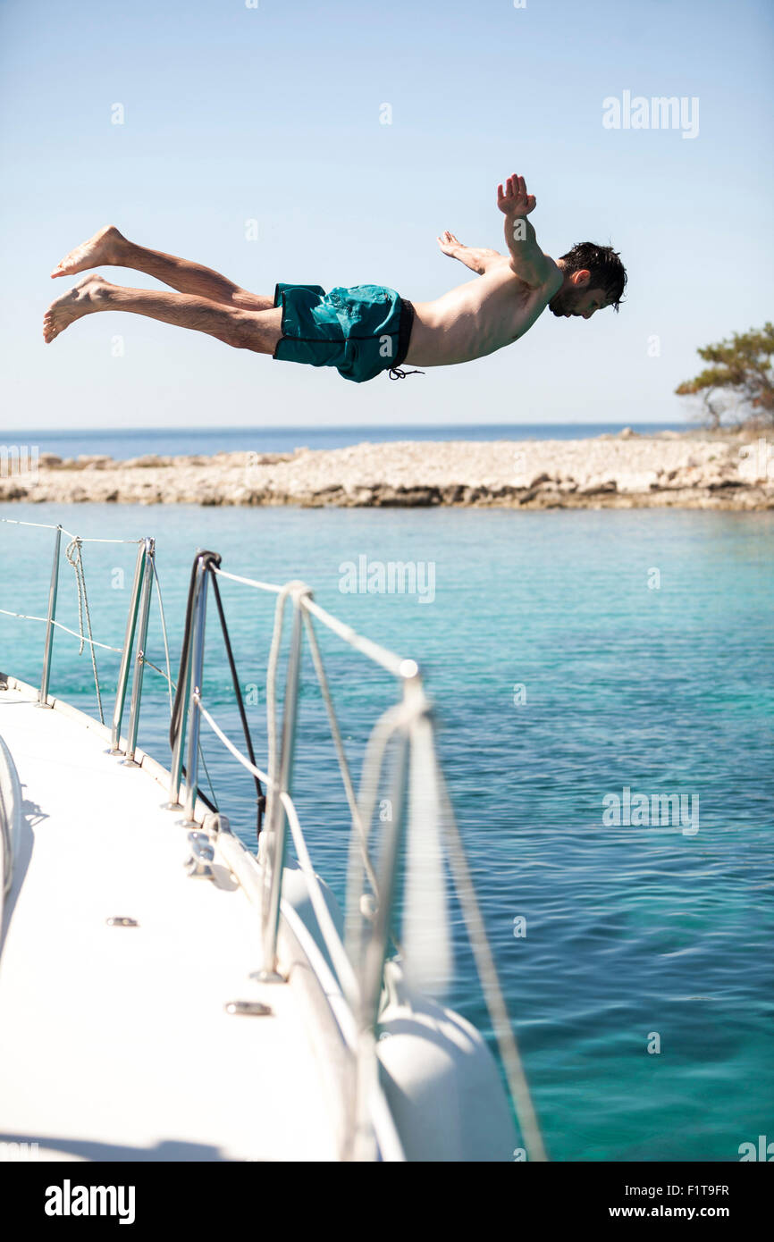 Young man diving into water from sailboat, Adriatic Sea Stock Photo