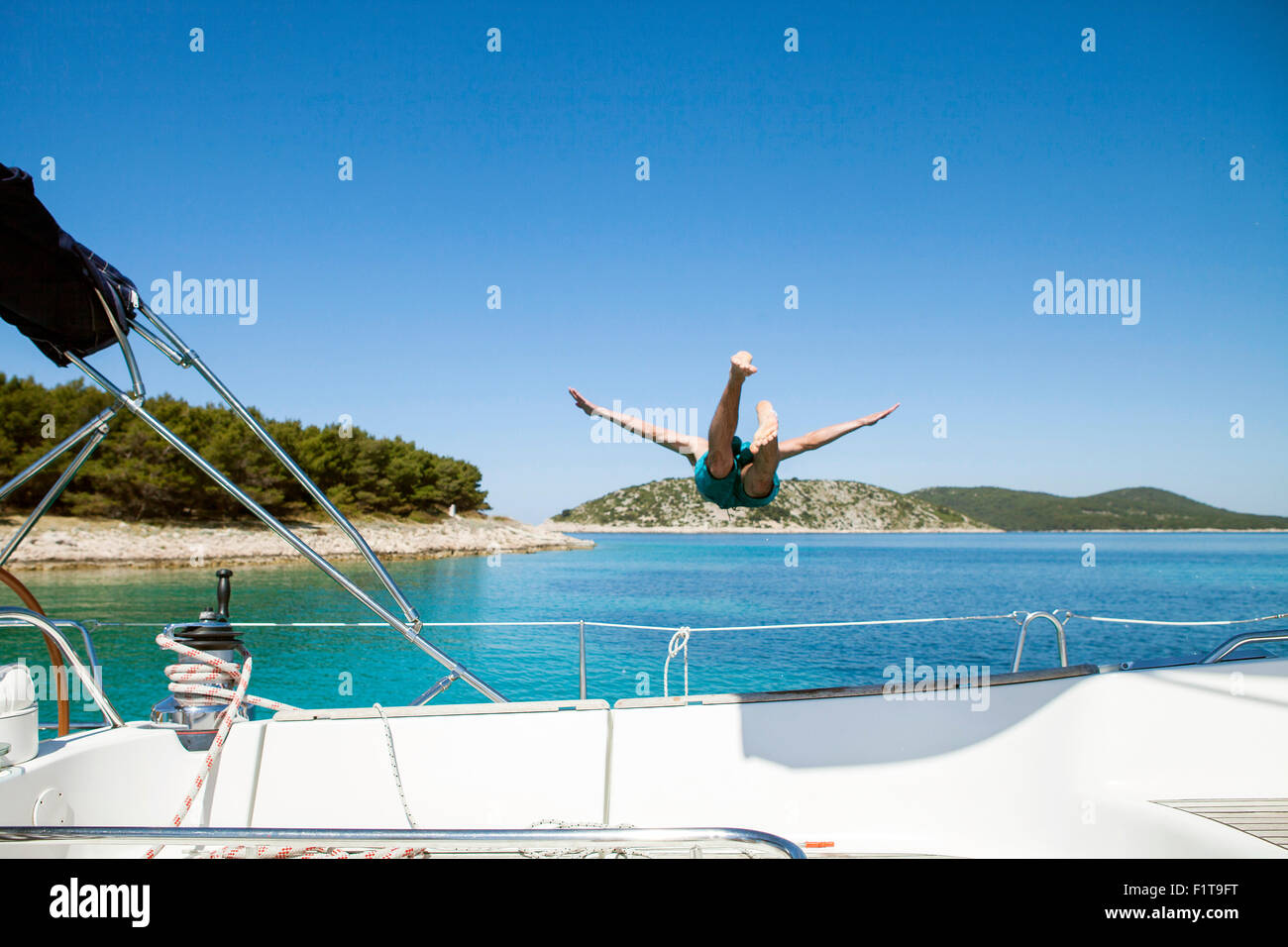 Young man diving into water from sailboat, Adriatic Sea Stock Photo