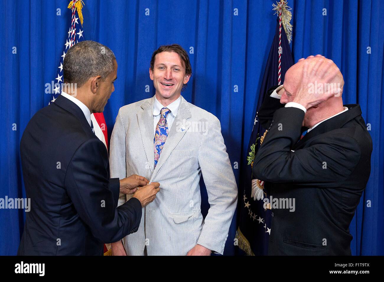 U.S. President Barack Obama adjusts a guest's jacket after he got caught in the rain prior to a town hall meeting with online communities 'BlogHer' and 'SheKnows' to discuss working families issues at ImaginOn April 15, 2015 in Charlotte, N.C. Stock Photo