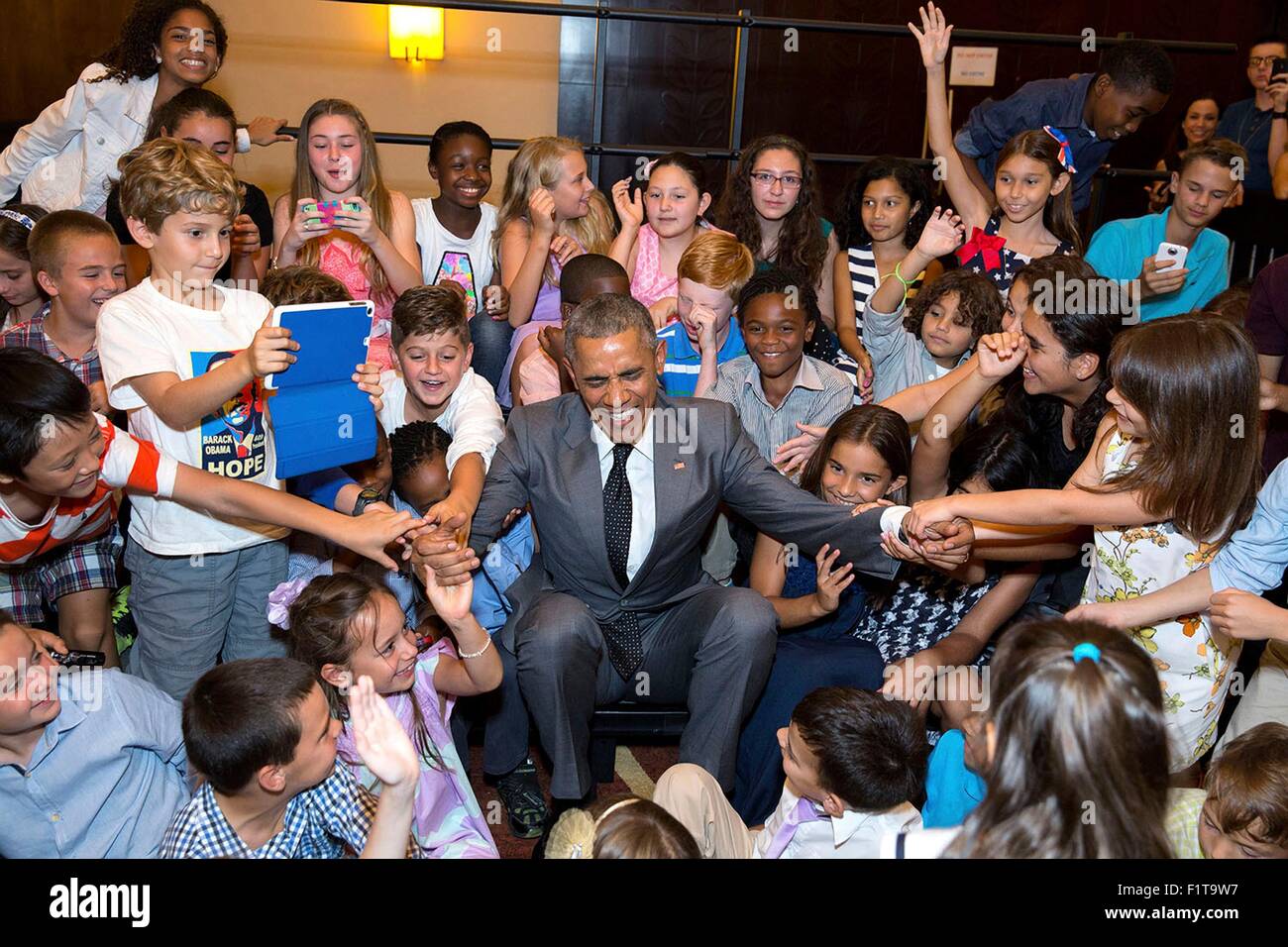U.S. President Barack Obama has help from a group of school children getting up after a group photo during a U.S. Embassy meet and greet April 9, 2015 in Panama City, Panama. Stock Photo
