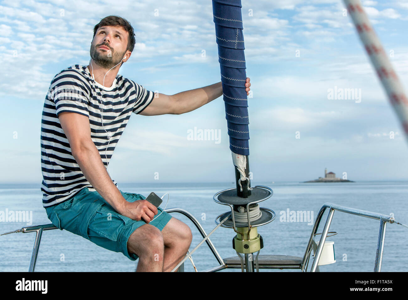 Man listening to music on sailboat, Adriatic Sea Stock Photo