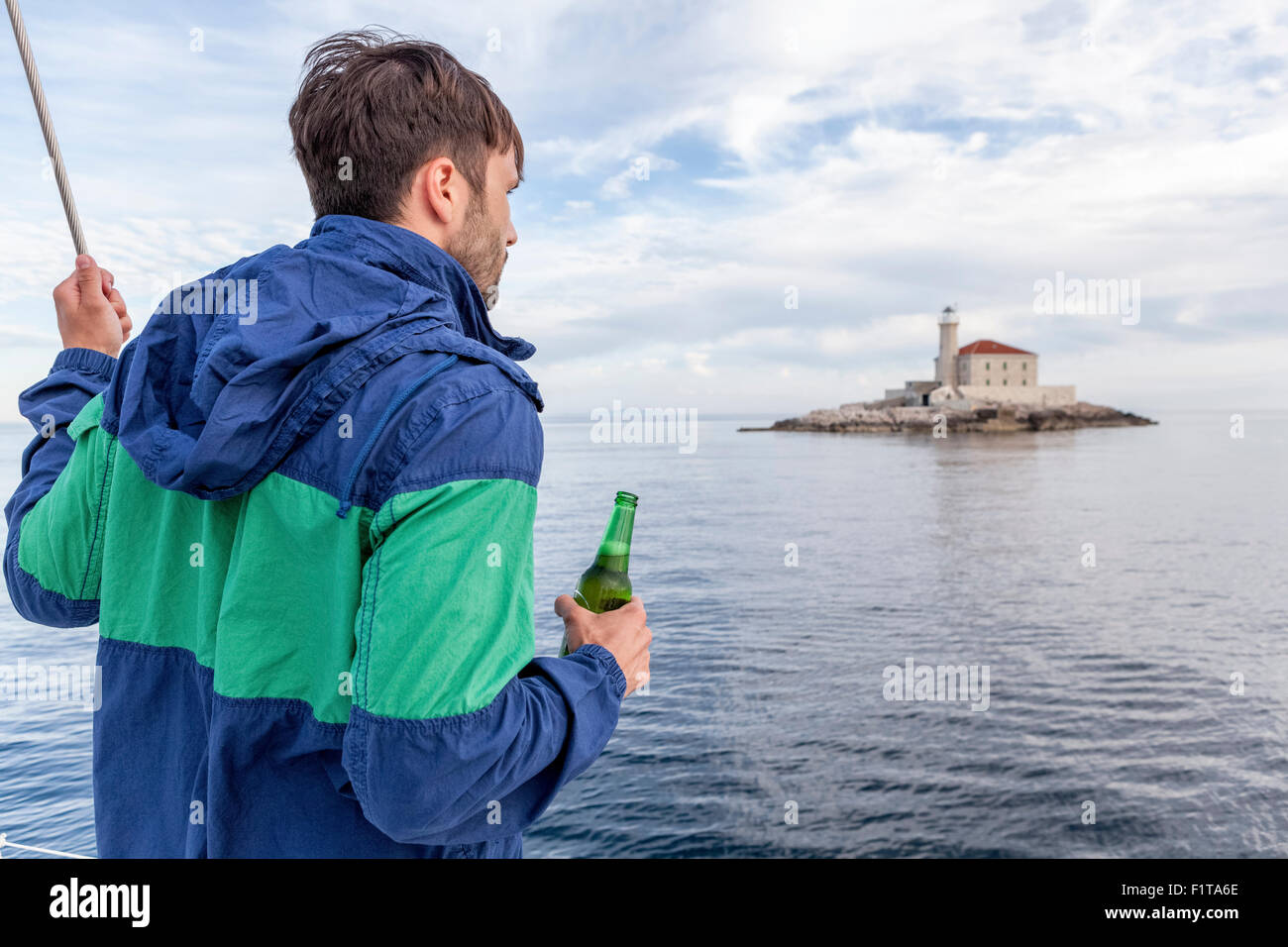 Man holding beer on sailboat, Adriatic Sea Stock Photo