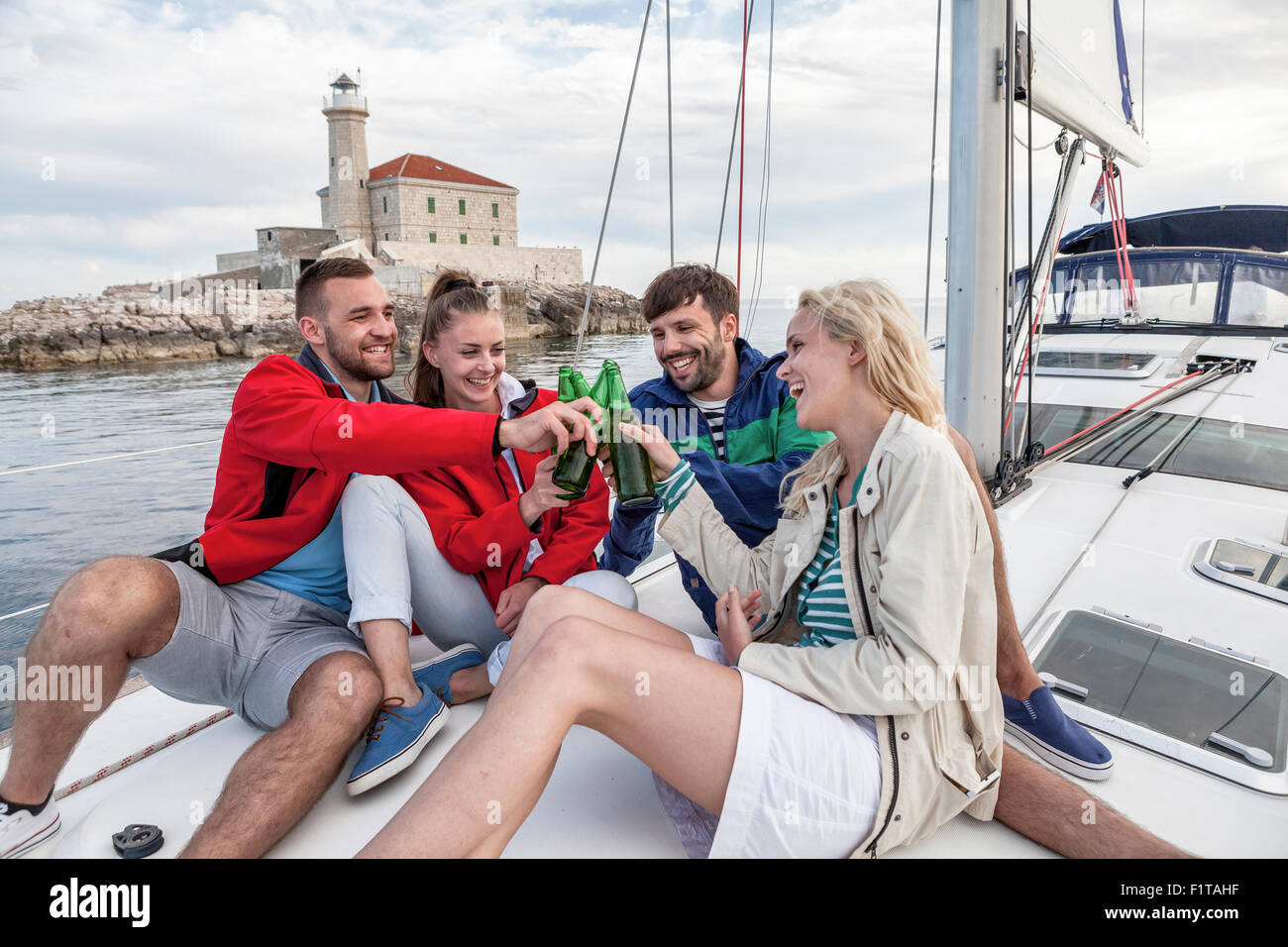 Group of friends drinking beer on sailboat, Adriatic Sea Stock Photo