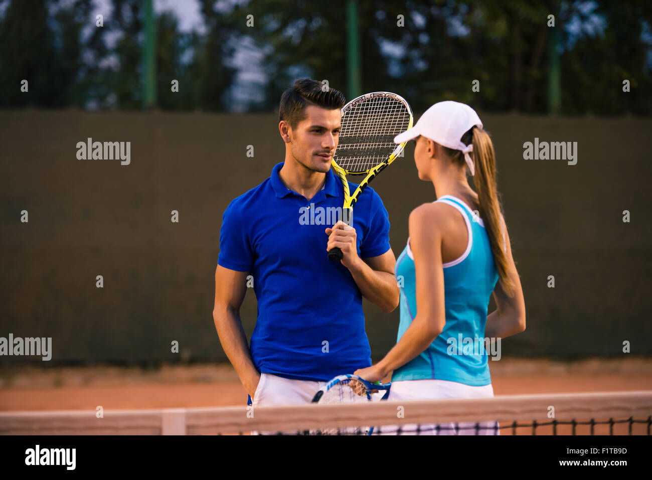 Portrait of a handsome man talking with her girlfriends at tennis court outdoors Stock Photo