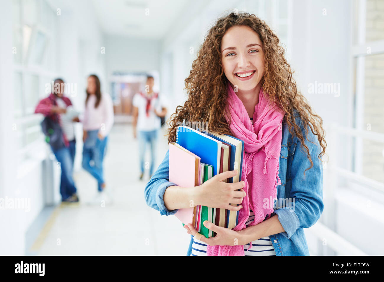 Smiling teenage girl with books looking at camera Stock Photo - Alamy