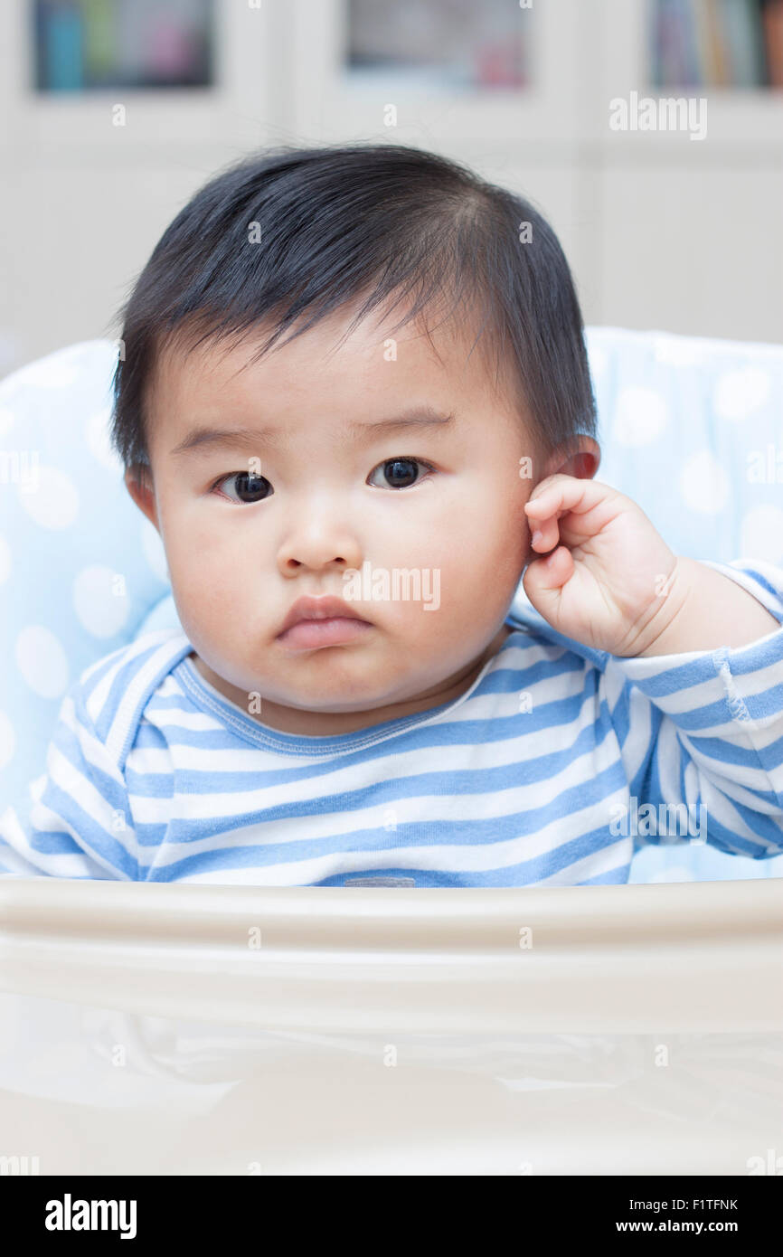 Cute Chinese baby boy sitting in baby chair Stock Photo