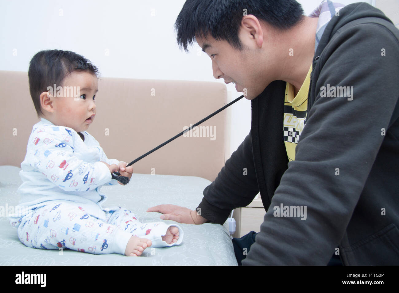 Chinese father and son playing in bed Stock Photo Alamy
