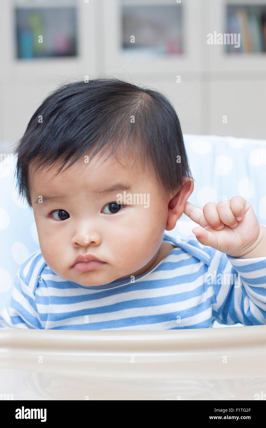 Cute Chinese baby boy sitting in baby chair Stock Photo