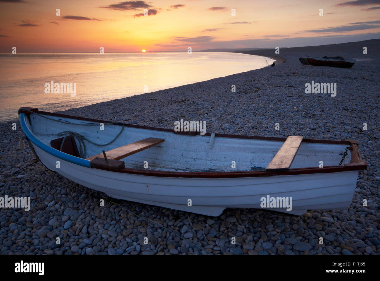 Boat on the beach at Chesil Cove during sunset, Chiswell, Portland on Dorset's Jurassic Coast, England, UK. Stock Photo