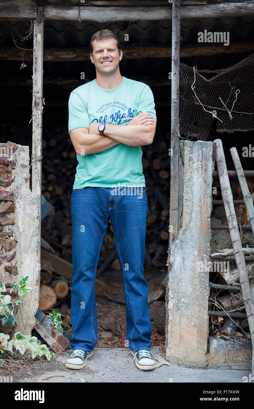 Tall rugby player stands in the doorway of a derelict building Stock Photo