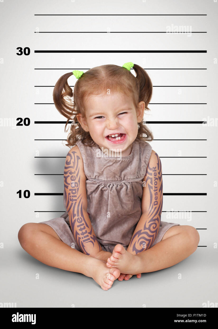 Mugshot, funny naughty baby with tattoo, disobedient child concept. Stock Photo