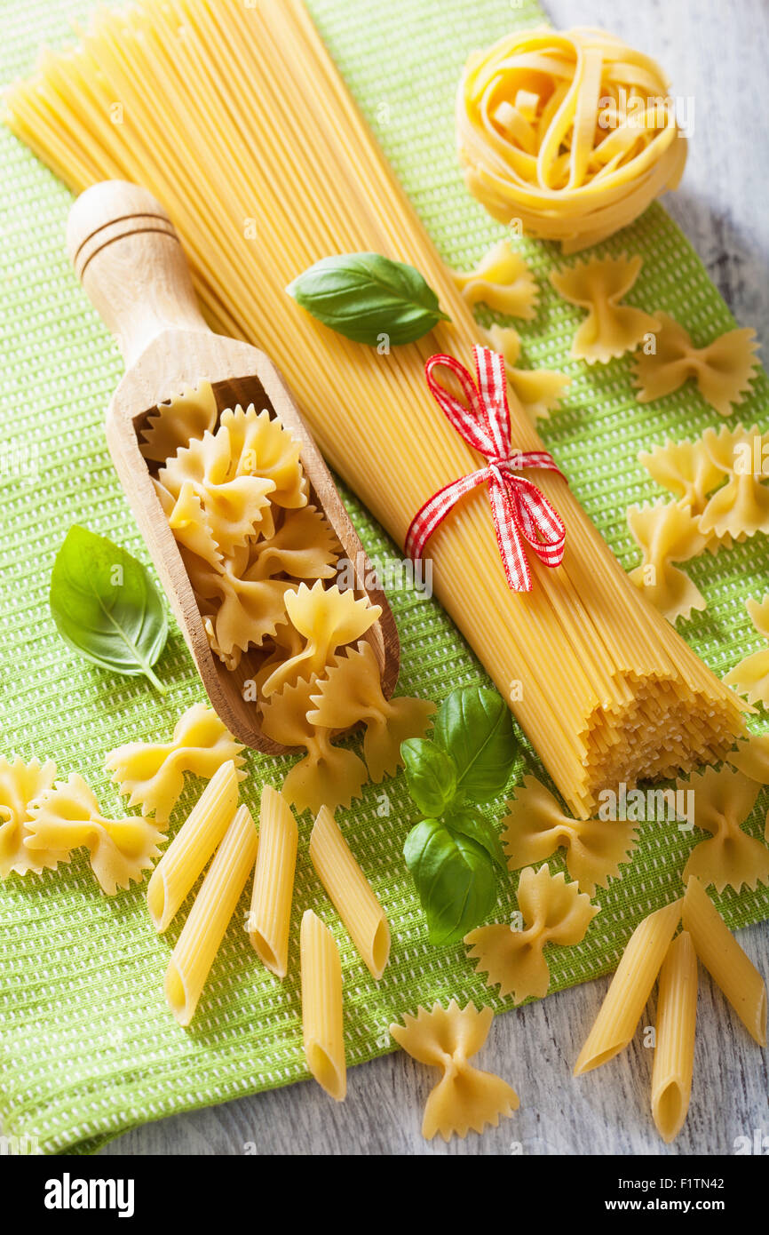 raw pasta spaghetti farfalle penne, tomatoes. italian cuisine Stock Photo